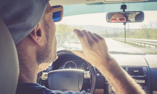 Portrait of a Man driving his Car and drinking water